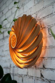 a light that is on the side of a brick wall next to a potted plant