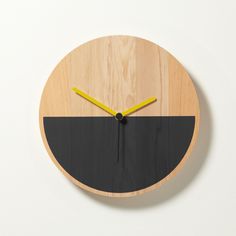 a wooden clock with black and yellow hands