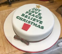 a christmas cake with the words joy, love, peace, believe and christmas written on it