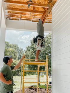 two men working on the roof of a house