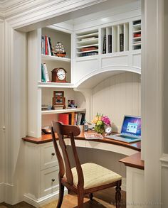 an open laptop computer sitting on top of a wooden desk next to a white book shelf