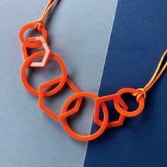 Bright orange mid-century modern geometric acrylic necklace which is stylish and perfect for the woman who likes contemporary style. My necklaces are light and easy to wear and will give your favourite outfit an instant pop of colour. A really unusual and interesting combination of three hexagons and four circles linked together and finished with silky orange cord and a silver plated magnetic clasp. It is mid-length and measures 26 inches long and hangs 14 inches from the clasp to the bottom lin Modern Orange Necklace As Gift, Modern Orange Necklace For Gift, Acrylic Necklace, Black Tissue Paper, Orange Jewelry, Lazer Cut, Jewellery Inspiration, Mid Century Jewelry, Bold Jewelry