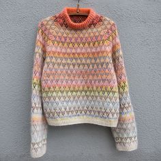 a multicolored sweater hanging on a wall