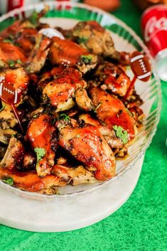 a bowl filled with chicken wings and garnished with cilantro on the side