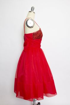 "Vintage 1950s party dress perfect for the holidays. Bright red nylon chiffon with red sequin panel along front of the bodice. Double spaghetti strap, boned, fitted top with ruched waist band and oversized back bow. Super full skirt from a gathered waist of chiffon with nylon under skirt and an additional stiff petticoat underneath. Hidden back metal zipper. Label: Only factory tag remains Fits like size: Small Measurements: Bust: 35-36\" Waist: 27\" Hip: free Length: 40\" Condition: Excellent. Red 1950s Style Evening Dress, 1950s Style Party Dress With Lined Bodice, Retro Party Dress With Lined Bodice, 1950s Red Party Dress, 1950s Style Red Party Dress, Red Vintage Sequin Dress, Vintage Red Sequin Dress, 1950s Party Dresses, 1950s Party