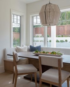 a dining room table with two chairs and a bench