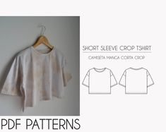 a white shirt hanging on a wall next to a hanger with the words short sleeve crop