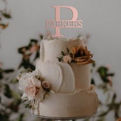 a wedding cake with flowers and the letter p on top