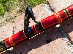 a red and black umbrella sitting on top of a brick wall