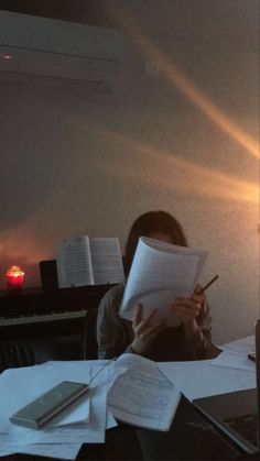 a person sitting at a desk with papers and an open book in front of them