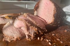 sliced meat sitting on top of a wooden cutting board