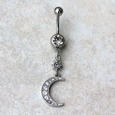 • Belly Button Ring / Navel Ring with a Moon & Star Dangle• A star and a crescent moon dangles from navel ring• Multiple Clear CZ throughout the jewelry• Bar Thickness : 14GA | 1.6mm• Bar Length : 3/8" | 10mm• Total Jewelry Size : 12(L) x 54(W)mm• Thread Type : Externally Threaded• Material : 316L Stainless Steel, Zinc Alloy, Cubic Zirconia Silver Star Belly Rings, Adjustable Silver Celestial Body Jewelry, Silver Adjustable Celestial Body Jewelry, Adjustable Silver Celestial Belly Rings, Adjustable Celestial Silver Belly Rings, Beachy Anklets, Celebrity Style Jewelry, Jewelry Bar, Meditation Accessories