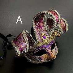 Jingle your way into an event and entertain an audience with the purple/gold Jester mask. The glossy embroidery will brighten the party. Venetian Masks And Prosthetics For Mardi Gras Party, Venetian Masks For Mardi Gras Costume Party, Venetian Masquerade Mask For Mardi Gras Costume Party, Red Costume Accessories For Mardi Gras, Multicolor Masks For Costume Party And Carnival, Venetian Masks For Festivals And Parties, Multicolor Masks And Prosthetics For Party And Carnival, Venetian Masks And Prosthetics For Festivals And Parties, Multicolor Masks And Prosthetics For Mardi Gras Costume