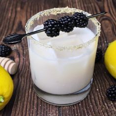 a glass with some blackberries on top of it