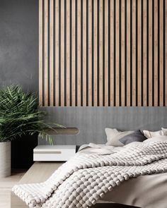 a large bed sitting next to a plant in a room with wooden slats on the wall