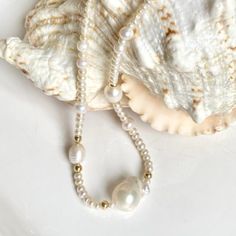 Adorn yourself with this exquisite pearl necklace. Handcrafted with large baroque pearls, this unique piece is sure to make you stand out. Wear it alone or with a stack of different pearl necklaces to create the timeless "messy" Chanel look. One of a kind. Length 17" Freshwater Pearls are symbolic of wisdom and are believed to attract good luck and wealth. Solar Plexus/Sacral Chakra -This information is intended for spiritual support only- Center Baroque Pearl W 16mm, L 23mm Components 14K gold White Beaded Baroque Pearl Necklace With Pearl Charm, White Baroque Pearl Necklace With Charm, White Single Strand Baroque Pearl Necklace, White Baroque Single Strand Pearl Necklace, Pink Baroque Pearl Single Strand Necklace, Classic Pearl Necklace, Baroque Pearl Necklace, Pearl Necklaces, Sacral Chakra