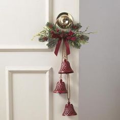 the door is decorated with bells and greenery