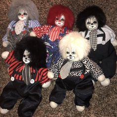 several clown dolls are laying on the carpet