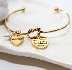 two personalized gold bracelets on a white plate