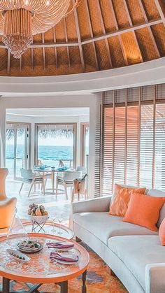 a living room filled with furniture and a chandelier hanging over the top of it