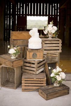 several wooden crates stacked on top of each other with wedding cakes in them and flowers