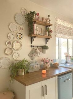 a kitchen with plates on the wall and dishes hanging above the counter top, along with potted plants