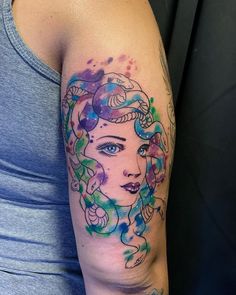 a woman's arm with watercolor tattoos on it and an image of her face