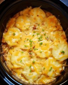 a crock pot filled with potatoes and cheese