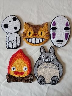 four embroidered patches with cartoon characters on them, one has a cat and the other has a dog