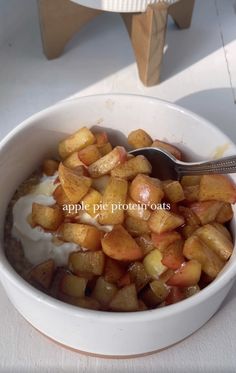 a white bowl filled with apples and yogurt