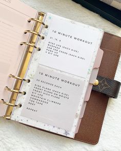 an open planner book sitting on top of a white blanket