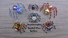 four spider ornaments are sitting on a wooden surface with the words aloho, bedecklights, beaded wire soldiers