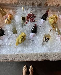 an assortment of wine bottles and grapes on ice