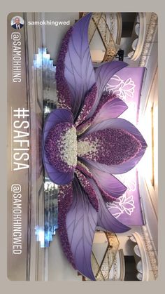 a large purple flower sitting on top of a table