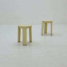 two small stools sitting next to each other on a white floor