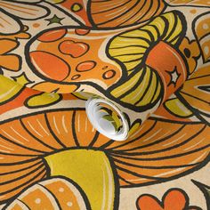 an orange and yellow flowered fabric with white circles on the center, in front of it