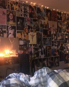 a bedroom with many pictures on the wall and candles lit up in front of it