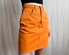 Vintage high waisted denim pencil mini skirt in bright orange. Classic 5-pocket styling, zipper fly with button. ✏️ TAGS DALLAS JEANS COMPANY Made in Finland 100% cotton SIZE Tag on item 29 Will fit waist 27" 28" (shown on 26") ✂️ CONDITION  Good vintage condition, cleaned and ready to wear. 📏 MEASUREMENTS Measured laying flat, please double for circumference:  length 18" 46 cm waist 13" 33 cm hips 18" 46 cm 📌 PLEASE NOTE  If you're in doubt, please ask for more measurements or information. Al Orange Fitted Retro Mini Skirt, Fitted Retro Orange Mini Skirt, Orange Cotton Mini Skirt For Spring, Orange Retro Mini Skirt, Spring Orange Cotton Mini Skirt, Orange Cotton Mini Skirt, Retro Orange Mini Skirt, Orange Mini Skirt Bottoms With Pockets, Retro Orange Mini Skirt For Spring