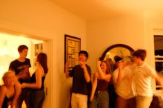 a group of people standing in a living room next to each other with their arms around one another