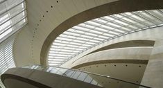 the inside of a modern building with glass and steel roofing, looking up into the sky