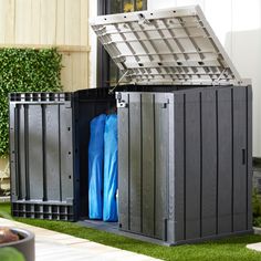 two large storage containers sitting in the grass