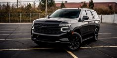 a black chevrolet suv parked in a parking lot