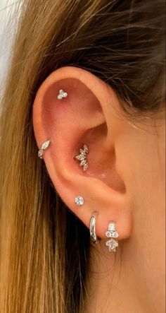 a woman's ear with three different piercings on it, including an ear cuff and