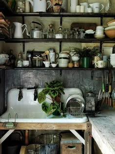 an old kitchen with lots of pots and pans on the shelf above the sink