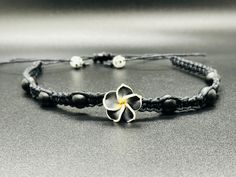 Matte black Onyx (natural) stones Plumeria hawaiian Flower Beautiful beaded hemp choker! * Hand-crafted square knot macrame * Adjustable * Opens up to 31" to fit overhead * 100% 1mm hemp cord * Slide knot closure for easy removal This hemp choker is made in traditional macrame square knots with black hemp and with natural matte onyx stones . Each of these beachy boho choker necklace is made adjustable for OSFM. Please message me with any questions. Thank you for choosing handmade and supporting Hand Wrapped Black Jewelry For Beach, Hand Wrapped Black Beach Jewelry, Adjustable Hippie Flower Jewelry, Black Spiritual Jewelry For The Beach, Spiritual Black Jewelry For Beach, Spiritual Black Jewelry For The Beach, Black Bohemian Jewelry With Adjustable Cord, Bohemian Black Jewelry With Adjustable Cord, Adjustable Black Flower Jewelry