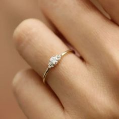 a woman's hand with a diamond ring on top of her finger, showing the side view