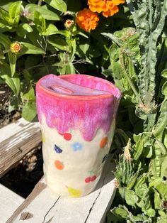 a colorful vase sitting on top of a wooden bench