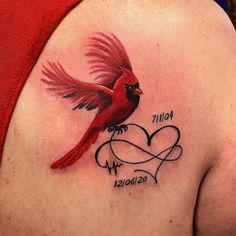 a woman's back shoulder with a red bird and heart tattoo on the side