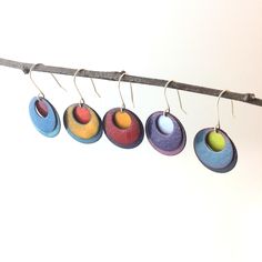 five colorful earrings hanging from a clothes line