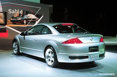 a silver sports car is on display at an auto show in front of a sign that says sabie